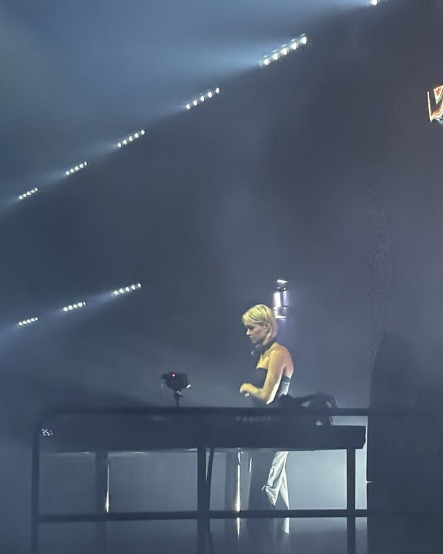 KI/KI playing in a dark room lit by white beams, February 2026