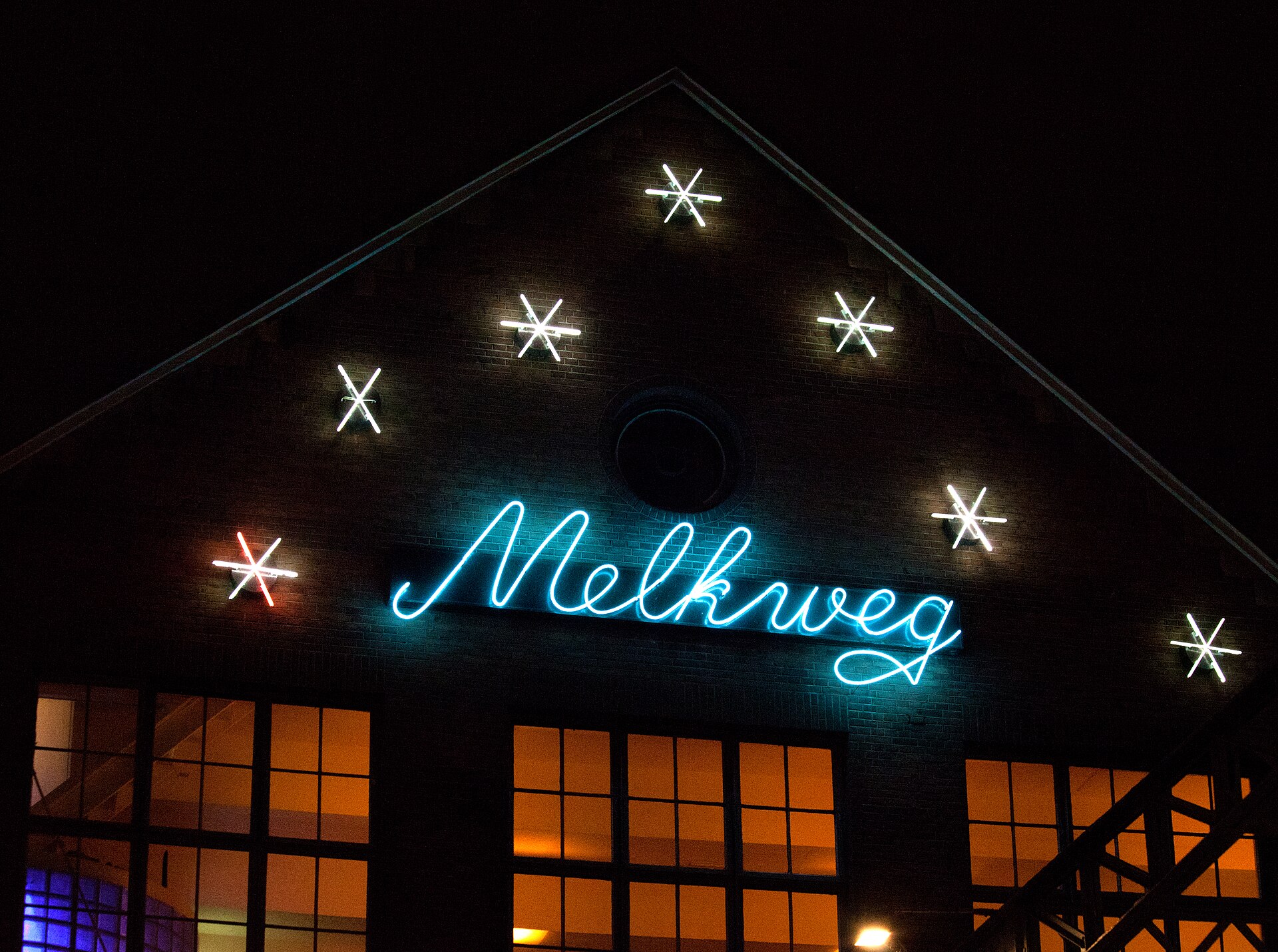 The Melkweg's neon sign glowing above lit windows at night